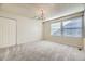 Bright bedroom featuring neutral carpet, a classic chandelier, and a window for natural light at 8208 S High Ct, Centennial, CO 80122