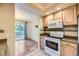 This bright kitchen features a white oven and microwave, wooden cabinets, and a sliding glass door at 8208 S High Ct, Centennial, CO 80122