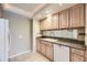 This kitchen features light wood cabinets, tiled backsplash, and modern appliances including a white dishwasher at 8208 S High Ct, Centennial, CO 80122