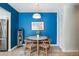 Charming dining area with a round table, stylish chairs, and bold blue accent wall at 1225 S Oneida St # 248, Denver, CO 80224