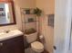 Small bathroom with a toilet, sink, and a shelf at 7505 W Yale St # 2103, Denver, CO 80227