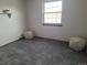 Bright bedroom with gray carpeting and two ottomans at 7505 W Yale St # 2103, Denver, CO 80227