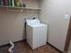 Laundry room with washer, shelving, and tile floor at 7505 W Yale St # 2103, Denver, CO 80227