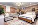 Finished basement bedroom with exposed brick walls, comfortable seating area, and a large bed at 1563 High St, Denver, CO 80218