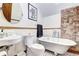 Charming bathroom with clawfoot tub, exposed brick, and pedestal sink at 1563 High St, Denver, CO 80218