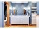 Bathroom with a double vanity, white cabinets, and oval mirrors at 1563 High St, Denver, CO 80218
