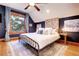 Spacious bedroom with a king-size bed, exposed brick accent wall, and hardwood floors at 1563 High St, Denver, CO 80218