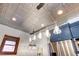 Kitchen features a tin ceiling, glass pendant lighting, and blue shaker cabinets at 1563 High St, Denver, CO 80218