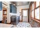 Well-appointed laundry room with modern washer and dryer, stylish cabinetry, and patterned tile floor at 1563 High St, Denver, CO 80218