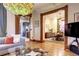 Living room features hardwood floors, a large TV, and an open floor plan to the dining area at 1563 High St, Denver, CO 80218