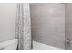 Bathroom featuring a tub with shower and gray tiling with a floral shower curtain, showcasing modern comfort at 2366 S Troy St, Aurora, CO 80014