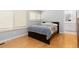 Bright bedroom featuring wood floors, a modern bed frame, and ample natural light through window shutters at 2366 S Troy St, Aurora, CO 80014