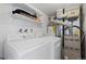 Functional laundry room with modern washer, dryer, shelves, and utility equipment at 2366 S Troy St, Aurora, CO 80014