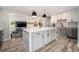 Bright kitchen featuring a large center island with white countertop, stainless steel appliances, and ample lighting at 1892 S Meade St, Denver, CO 80219