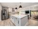 Modern kitchen with large island, stainless steel appliances, and open floor plan to the living area at 1892 S Meade St, Denver, CO 80219
