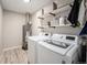 Functional laundry room featuring modern washer and dryer, overhead storage shelves, and water heater at 1892 S Meade St, Denver, CO 80219