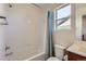 Bright bathroom featuring a shower-tub combo, with a modern vanity, toilet, and window at 10023 Uravan St, Commerce City, CO 80022