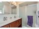 Modern bathroom featuring double sinks, a glass-enclosed shower, and updated fixtures at 10023 Uravan St, Commerce City, CO 80022