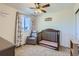 Cozy bedroom featuring a crib, chair, carpet flooring, and natural light from the window at 10023 Uravan St, Commerce City, CO 80022