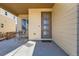 Covered front porch with seating area and a woodgrain door at 10023 Uravan St, Commerce City, CO 80022