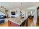 Kitchen with granite island, stainless sink, and open view to dining and living areas at 10023 Uravan St, Commerce City, CO 80022