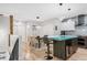 Open-concept kitchen and dining area with a unique glass island and modern lighting fixtures at 3295 Blake St # 102, Denver, CO 80205