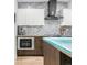 Well-equipped kitchen with stainless steel appliances, a custom range hood, and modern white cabinets at 3295 Blake St # 102, Denver, CO 80205