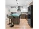 Modern kitchen with unique glass-topped island, breakfast bar seating, stainless steel appliances and hardwood floors at 3295 Blake St # 102, Denver, CO 80205