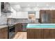 Kitchen with stainless steel appliances, glass island, wood cabinets, and hard wood floors at 3295 Blake St # 102, Denver, CO 80205