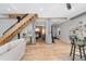 Bright living room featuring wood floors, modern staircase, and an open layout to the bedroom at 3295 Blake St # 102, Denver, CO 80205
