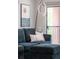 Close-up of a plush sofa with decorative pillows, a modern lamp, and a view to the outdoor balcony at 3295 Blake St # 102, Denver, CO 80205