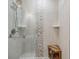 Modern shower with stone tile accent, rainfall shower head, and convenient bench seating at 3295 Blake St # 102, Denver, CO 80205