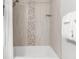 Close-up of shower showing decorative tile and shower head at 3295 Blake St # 102, Denver, CO 80205