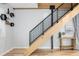 Staircase featuring a sleek black railing and wood treads, accented by geometric shelving and contemporary decor at 3295 Blake St # 102, Denver, CO 80205