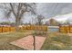 Large backyard with grass, mature trees, wooden fence, brick patio and storage shed at 9295 E 12Th Ave, Aurora, CO 80010