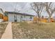 A spacious backyard featuring grass, trees, a brick patio, and wood fencing at 9295 E 12Th Ave, Aurora, CO 80010