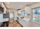 Modern kitchen featuring white cabinets, stainless steel appliances, and elegant countertops, flowing into dining area at 9295 E 12Th Ave, Aurora, CO 80010