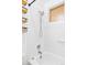 Bright white tiled bathroom featuring a shower and tub with elegant fixtures at 822 S Worchester St, Aurora, CO 80012