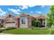 Charming single-Gathering home featuring a stone and green siding, manicured lawn, and attached garage at 14879 Xenia St, Thornton, CO 80602