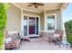 Cozy front porch with comfortable seating, stone accents, and a ceiling fan for outdoor relaxation at 14879 Xenia St, Thornton, CO 80602