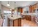 Modern kitchen features cherry cabinets, granite countertops, stainless appliances, and hardwood floors at 14879 Xenia St, Thornton, CO 80602