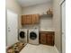 Well-equipped laundry room featuring washer, dryer, sink, and storage cabinets for convenience at 14879 Xenia St, Thornton, CO 80602