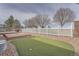 Backyard featuring an artificial turf putting green, rock landscaping, and white picket fence at 1260 S Duquesne Cir, Aurora, CO 80018