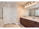 Bathroom with dual sinks, dark wood cabinets, and a glass-enclosed shower at 1260 S Duquesne Cir, Aurora, CO 80018