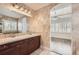 Bathroom featuring dual sinks, vanity with dark wood cabinets, and archway to bedroom at 1260 S Duquesne Cir, Aurora, CO 80018