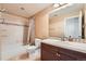 Full bathroom featuring a shower and bath combo, white tile, and vanity with solid surface counter at 1260 S Duquesne Cir, Aurora, CO 80018