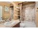 Full bathroom featuring a shower and bath combo, earth-toned tile, and vanity with solid surface counter at 1260 S Duquesne Cir, Aurora, CO 80018