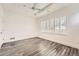 Bedroom featuring wood-look floors, bright white walls, modern ceiling fan, and shuttered windows at 1260 S Duquesne Cir, Aurora, CO 80018