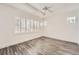 Bedroom featuring wood-look floors, bright white walls, a modern ceiling fan, and shuttered windows at 1260 S Duquesne Cir, Aurora, CO 80018