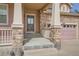 Close-up of a home entrance with stone accents, porch, and glass pane front door at 1260 S Duquesne Cir, Aurora, CO 80018